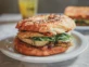 Bagel de pollo asado, palta, huevo, pesto de tomates secos y rúcula