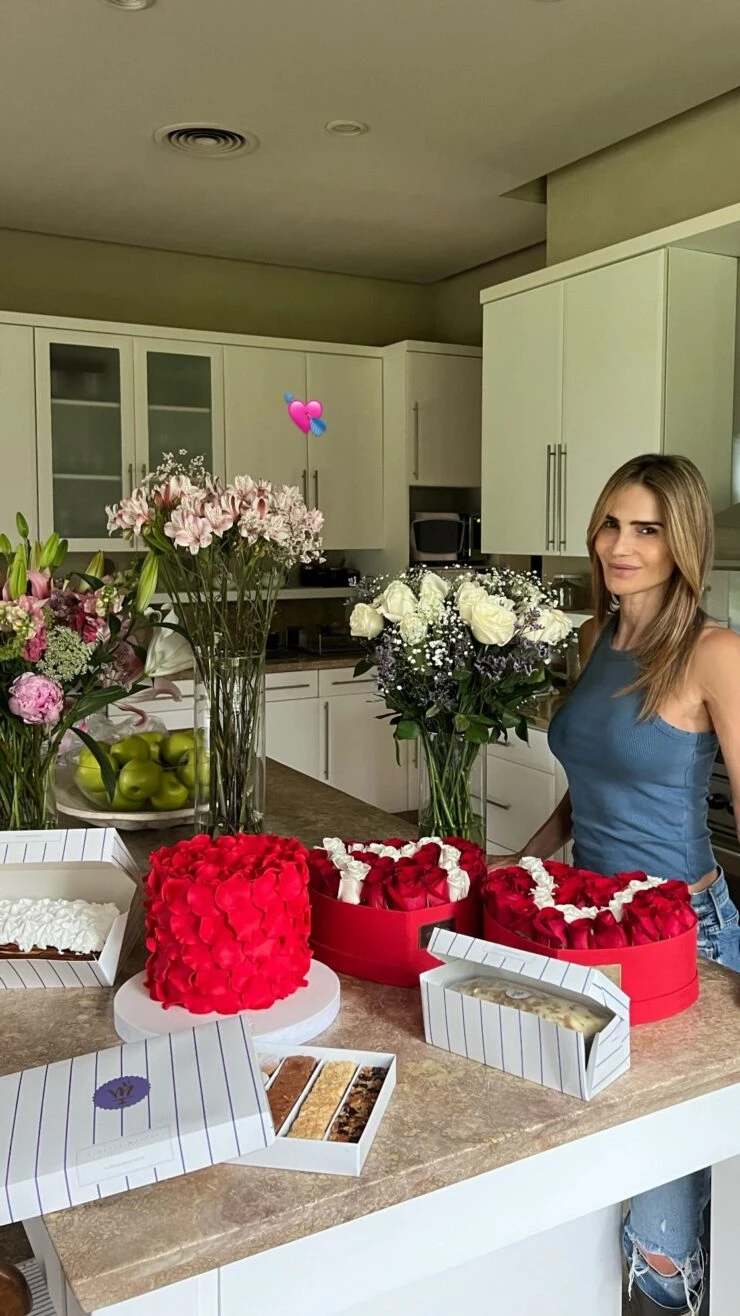 María Vázquez con flores de regalo y productos de pastelería.