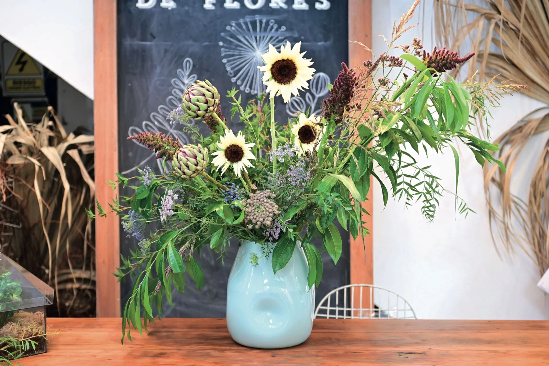 Los girasoles son protagonistas de un arreglo natural con mucho follaje. 