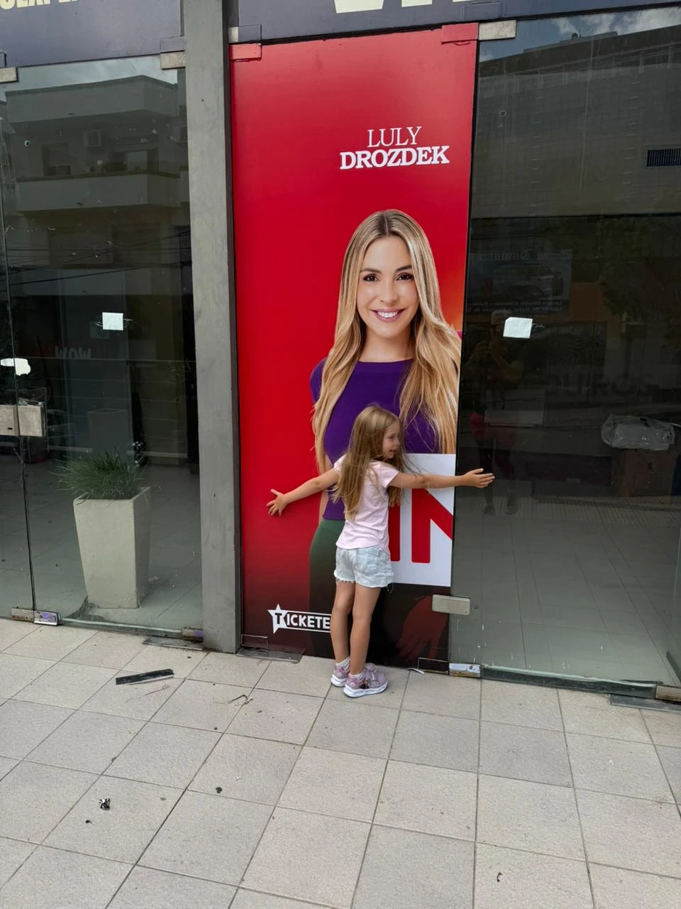 Delfina abraza la imagen de su mamá en la puerta del teatro